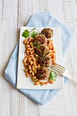 Meatballs on white beans with herbs