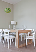 White chairs at modern wooden table in simple dining room