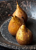 Three organic conference pears in a stone bowl