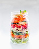 Vegetable salad with cashew nuts in a glass jar