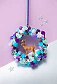 Stag figurines in colourful wreath of pompoms