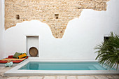 Partially rendered stone wall behind swimming pool