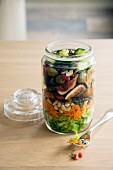 Vegan salad with vegetables, fruit and nuts in a glass jar