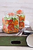 Bulgur wheat salad with pomegranate syrup, onions, cucumber, tomatoes, parsley and mint in a glass jar