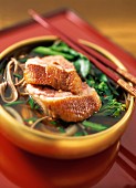 bowl of duck and noodle soup in oriental setting