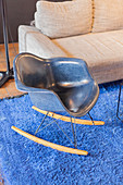 Blue designer rocking chair on bright blue rug