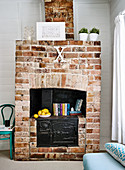 Vintage ornaments on black range stove in brick fireplace