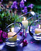 Atmospheric table decorations: Lit candles in glass bowls with angled openings at twilight