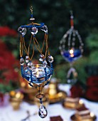 Atmospheric garden decorations: Gel candles in suspended holders decorated with beads and crystals