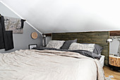 Double bed in attic room with rustic elements