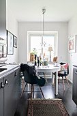 Round table and shell chairs in front of window in kitchen-dining room