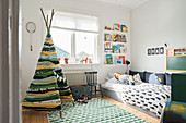 Hand-made teepee in child's bedroom in shades of green