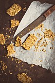Homemade muesli bars on baking paper with a knife