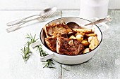 Lamb ribs with baked potatoes and onions in a pot