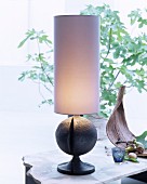 Table lamp with tall cylindrical lampshade and spherical base