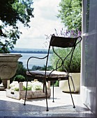 Metallstuhl und Lavendel auf der Terrasse mit Blick auf den See