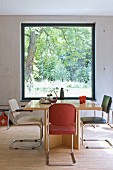 Retro cantilever chairs around wooden table in front of panoramic window