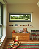 Rocking horse in child's bedroom with narrow horizontal window