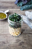 Layered salad with brown rice, chickpeas, palm kale and pesto