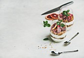 Healthy breakfast. Greek yogurt, granola and blood orange layered parfait in glasses with mint leaves