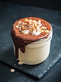 Vegan peanut butter banana smoothie with chocolate topping in a jar
