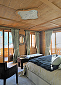 Bedroom with panelled ceiling and encircling balcony