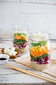 Vegan quinoa salad with vegetables and tofu in a glass jar