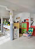 Breakfast car, columns and colourful eclectic furnishings in loft apartment