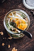 Salad with white cabbage, carrots, green salad, fennel, orange and walnuts in a jar, vegan