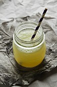 Ginger beer in a glass jar with a straw
