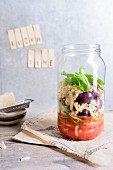 Quinoa salad with tomatoes, mozzarella and basil in a glass jar