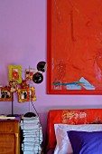 Red painting on purple wall in bedroom