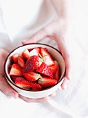 Fresh strawberries in a cup held by the gentle hands of a woman (Italy)