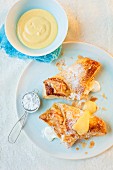Apple and quark turnovers with icing sugar and custard