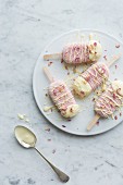 Rose and raspberry yoghurt frozen popsicles decorated with white chocolate and dried edible rose petals