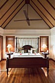 Elegantes Schlafzimmer mit romantischer Blütendekoration und beleuchteten Tischleuchten
