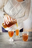 A Women is pouring Almond Lime Italian Soda into glassware