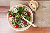 Vegan salad (einkorn wheat, tomatoes, lamb's lettuce, red onion rings, iceberg lettuce, cress, pepper) in a palm leaf bowl