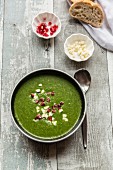 Green cabbage soup with pomegranate seeds and feta cubes