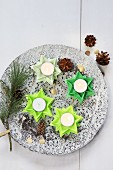 Folded green paper stars used as tealight holders