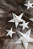 Folded white paper stars on fur