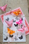 Origami-Schmetterlinge auf bedrucktem Papier