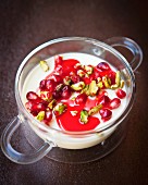 Cardamom and lemon dessert with pistachios, pomegranate seeds and rose syrup