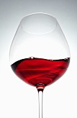 A wave of red wine in a glass