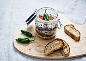 Rice, tomato sauce, fried peppers, soy meat, kidney beans and lentils in a glass jar, served with toasted bread
