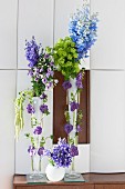 Vertical flower arrangement in shades of purple, blue and green