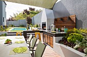 Pool, terrace and outdoor kitchen in summer garden surrounded by wall
