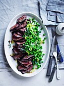 A hanger steak with pepper, peas and lettuce