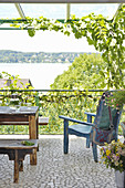 Balkon mit rustikalen Holzmöbeln und Seeblick