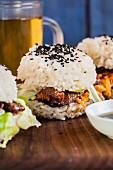 Sushi burgers with carrots, teriyaki meat, lettuce and black sesame